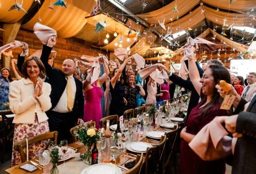 Wedding guests at tables celebrating arrival of bride and groom